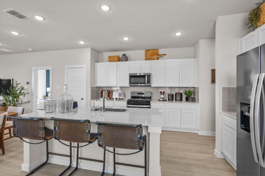 A kitchen with white cabinets.