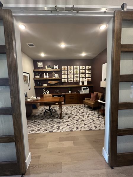 A sophisticated home office with a wooden desk, geometric rug, and decorative shelving for a modern aesthetic. A sophisticated home office with a wooden desk, geometric rug, and decorative shelving for a modern aesthetic.