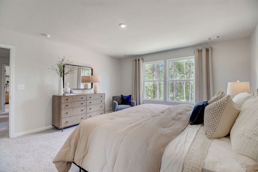 A large bedroom with a bed and a dresser.