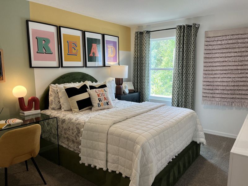 A cozy bedroom featuring colorful artwork, a plush bed, and stylish decor, perfect for relaxing and unwinding.