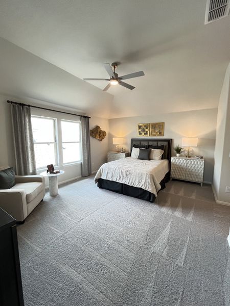 A spacious bedroom featuring a comfortable bed, stylish decor, cozy seating, and ample natural light.