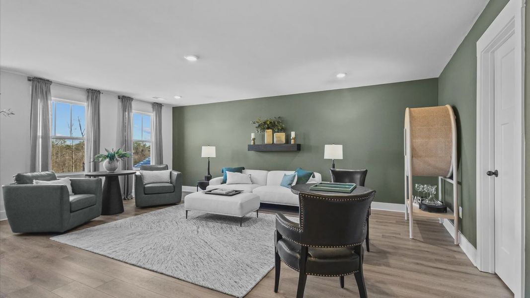 New two-story home with green accented loft space with hardwood flooring at Wells Crossing by DRB Homes in Seneca, SC