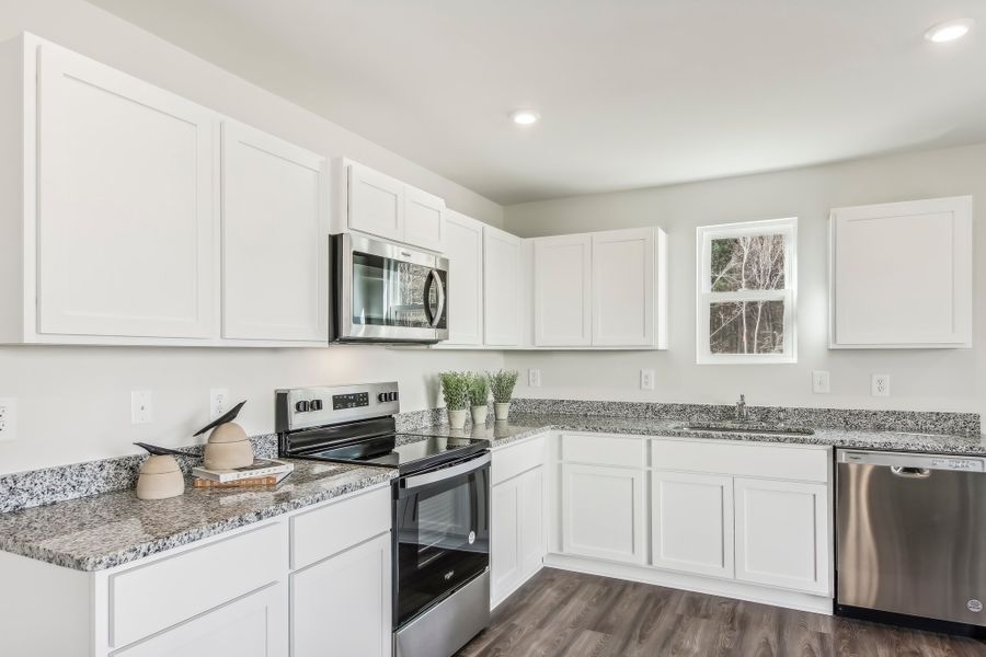 Kitchen with granite countertops and white cabinets.