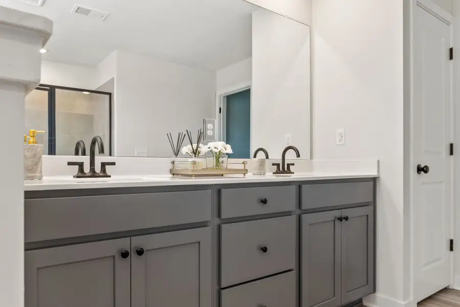 A bathroom with white cabinets.