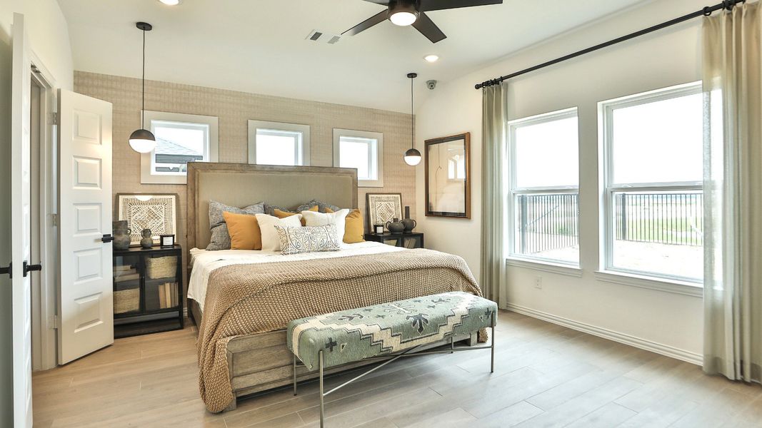 Exquisite modern bedroom with large windows, sleek ceiling fan, and plush furnishings in Bridgeland. Exquisite modern bedroom with large windows, sleek ceiling fan, and plush furnishings in Bridgeland.