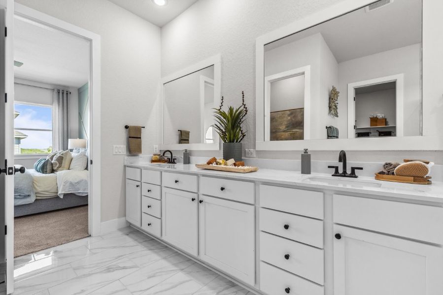 A bathroom with white cabinets.