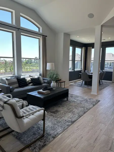 A bright living room with arch windows, modern furnishings, and a cozy seating area, seamlessly flowing into the dining space. A bright living room with arch windows, modern furnishings, and a cozy seating area, seamlessly flowing into the dining space.