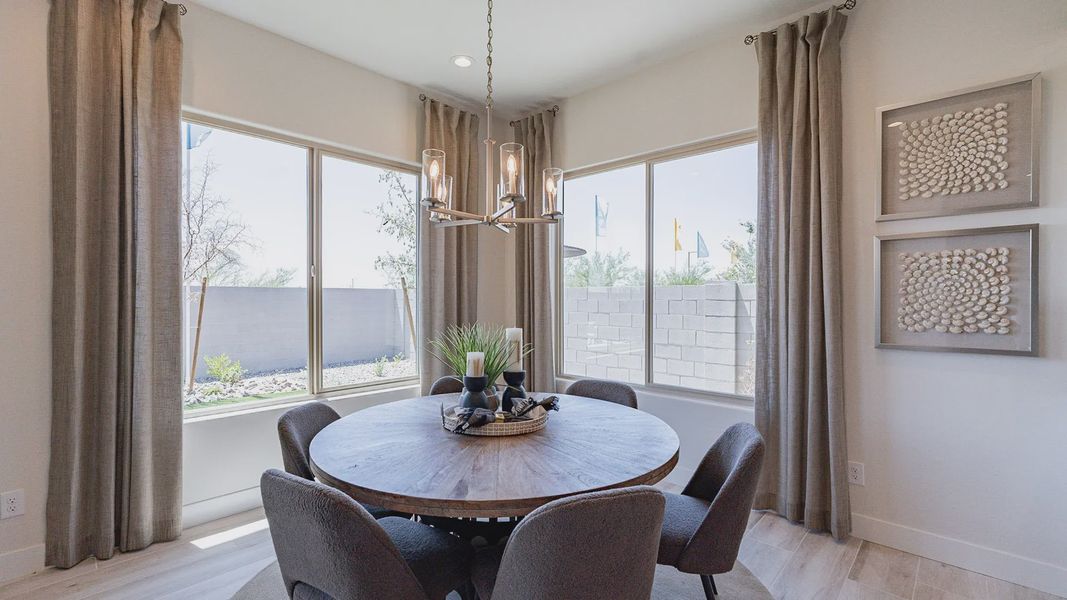 Discover refined elegance with a modern chandelier and wood table in Windrose's luxurious dining space.