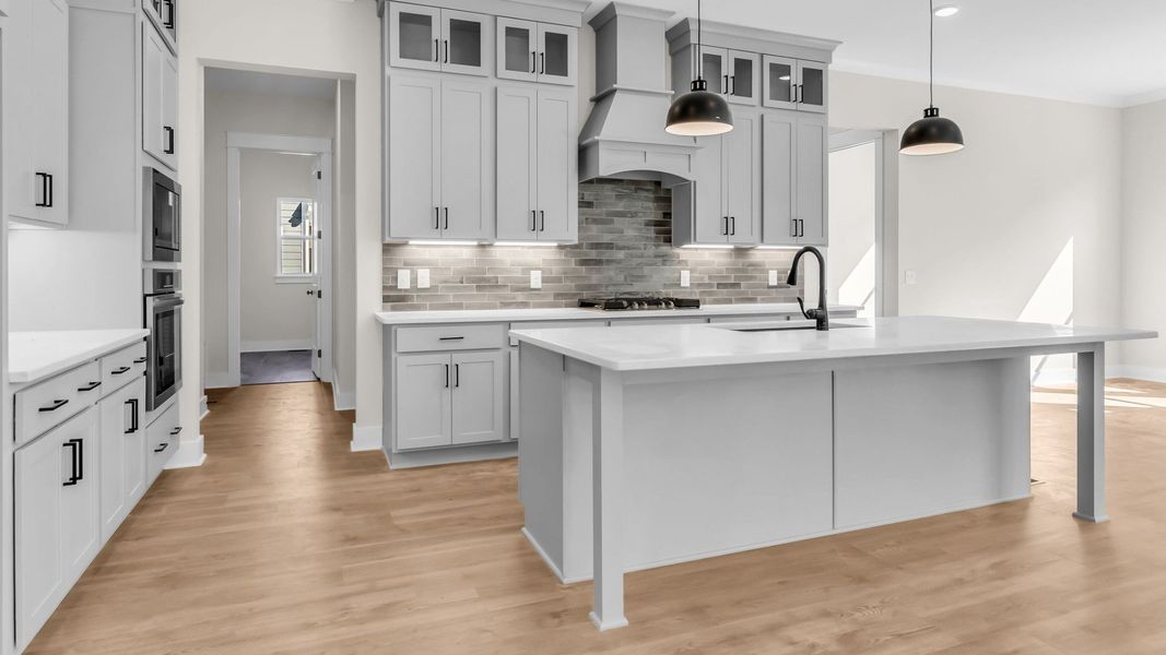 Kitchen with spacious light grey cabinetry, beautiful quartz countertops, and view into the dining area Kitchen with spacious light grey cabinetry, beautiful quartz countertops, and view into the dining area