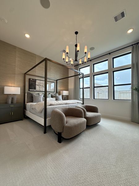 A cozy bedroom with a four-poster bed, elegant chandelier, and large windows offering abundant natural light. A cozy bedroom with a four-poster bed, elegant chandelier, and large windows offering abundant natural light.