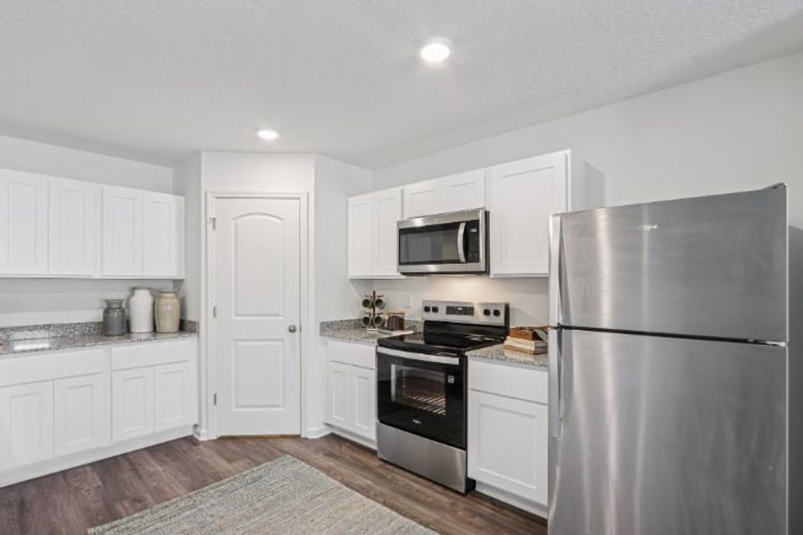 A kitchen with white cabinets.