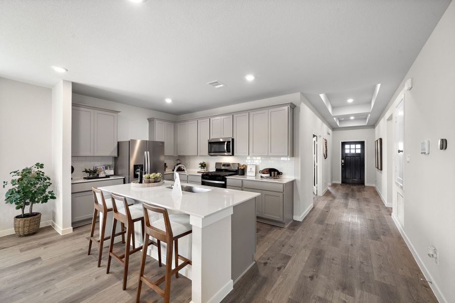 A kitchen with white cabinets.