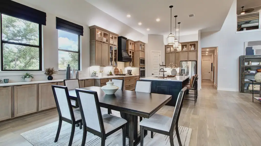 Elegant kitchen with custom wood cabinets, expansive island, and chic pendant lights in Verandas at the Rim.