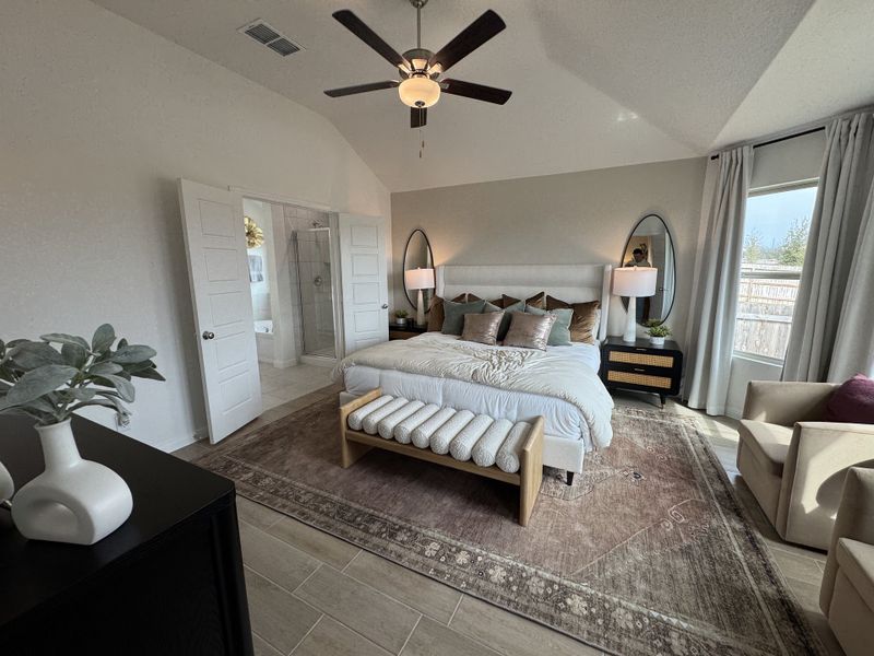 A cozy bedroom with a plush bed, elegant décor, and soft lighting, featuring a window view and modern furnishings.