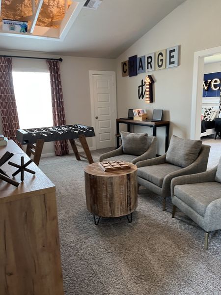 A cozy game room with plush seating, a foosball table, and rustic decor elements. Ideal for family fun and relaxation.