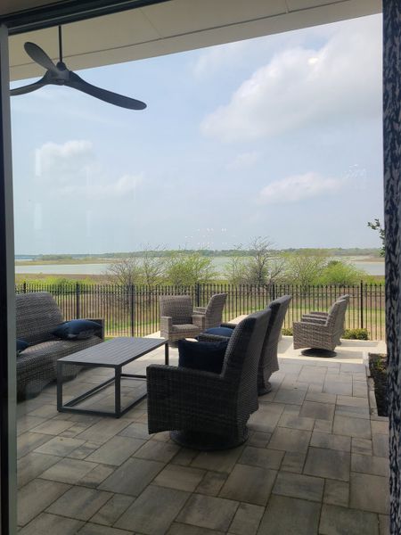A serene patio with wicker furniture, overlooking a lush landscape and water view, ideal for relaxation. A serene patio with wicker furniture, overlooking a lush landscape and water view, ideal for relaxation.