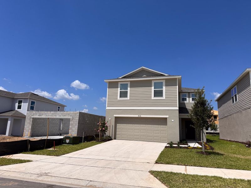 A contemporary two-story home with a spacious driveway and landscaped yard in Scenic Terrace by Taylor Morrison (Lake Hamilton, FL).