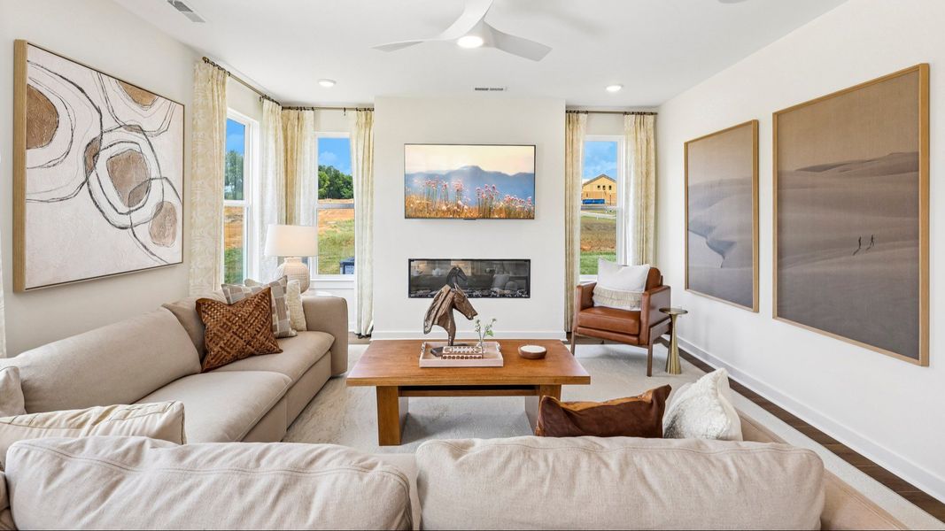 Gathering room with ceiling fan, windows, and fireplace