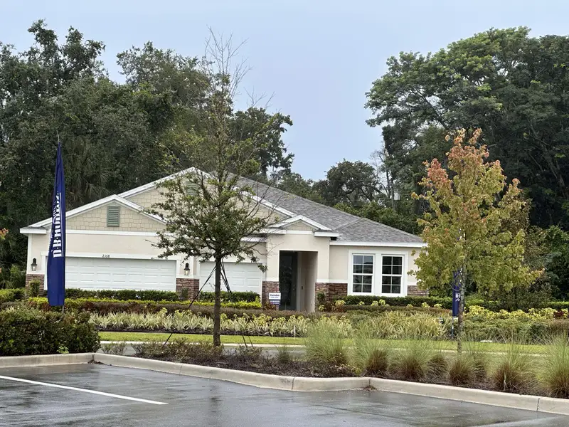 A charming beige home with a well-landscaped yard in Wynwood by D.R. Horton (Ocoee, FL).