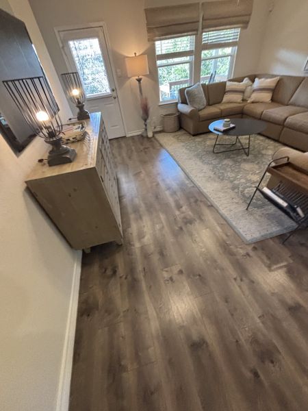 Cozy living room with warm lighting, a plush sectional sofa, and elegant wood flooring.