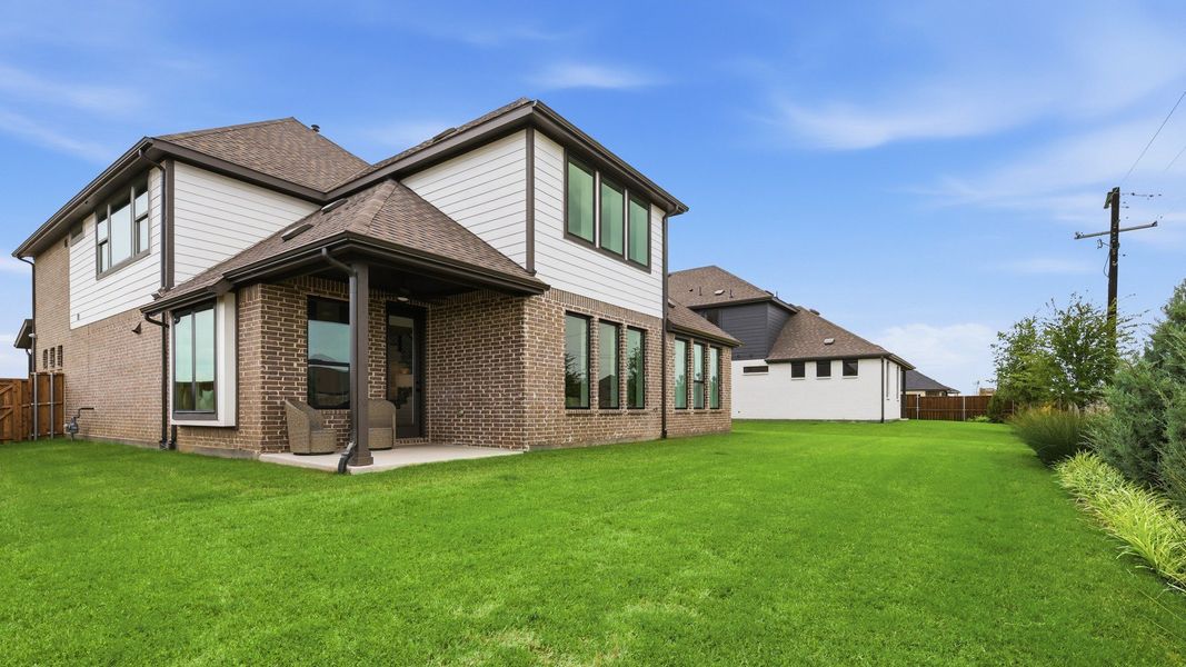 Elegant brick facade with expansive windows in Westridge showcases luxury living with a spacious backyard. Elegant brick facade with expansive windows in Westridge showcases luxury living with a spacious backyard.