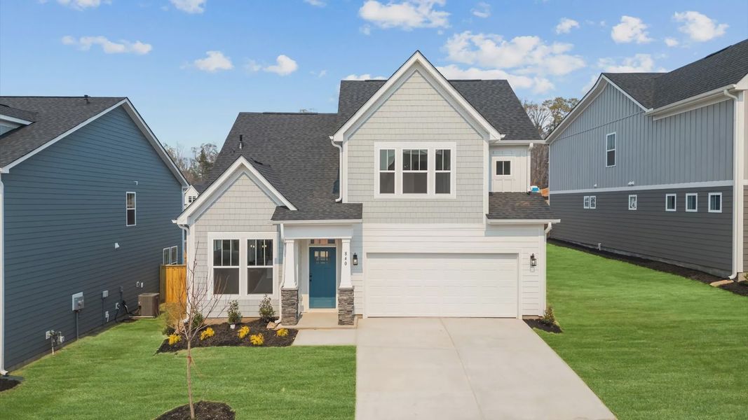 Cool toned exterior two story home with stone detailed columns, two car driveway, and one car garage at Pleasant Falls