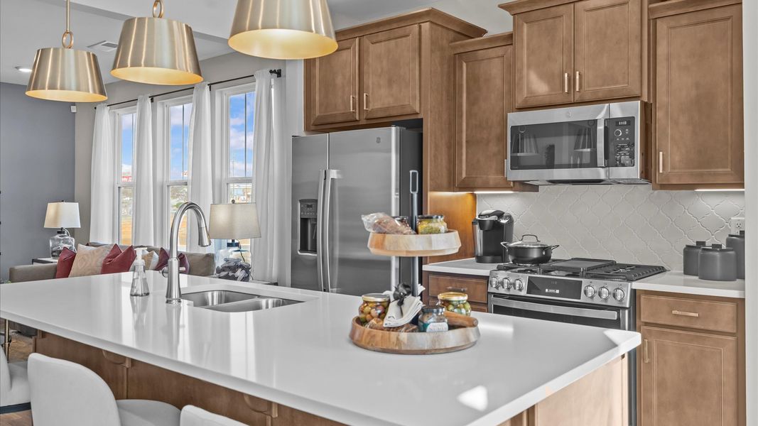 Highly skilled craftsmanship shines in this modern kitchen with pendant lighting and a central island focal point Highly skilled craftsmanship shines in this modern kitchen with pendant lighting and a central island focal point