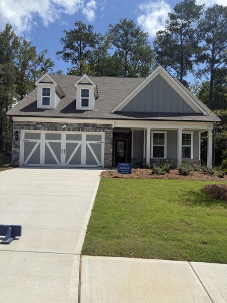 A charming gray-siding home with dormers and manicured lawn in Candleberry Place by Lennar, Sharpsburg, GA.