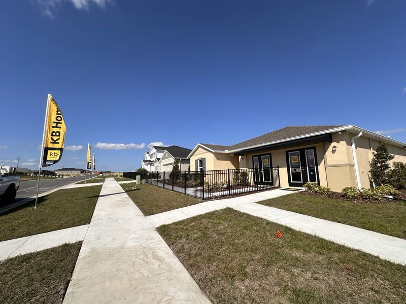 A KB Home sales center with model homes and bright blue skies in Landings at Lake Mabel Loop by KB Home (Dundee, FL).