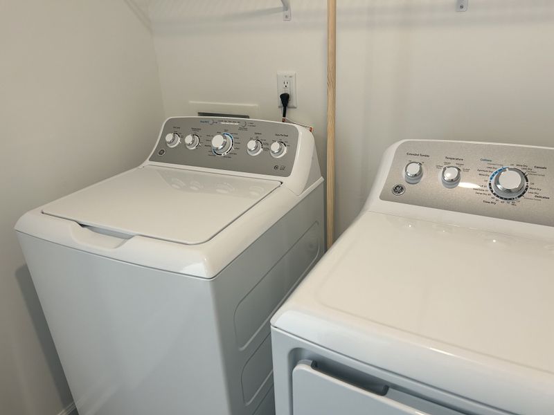 A welcoming laundry room with a top-load washer and dryer in Sherri Downs by Lennar (Angier, NC).