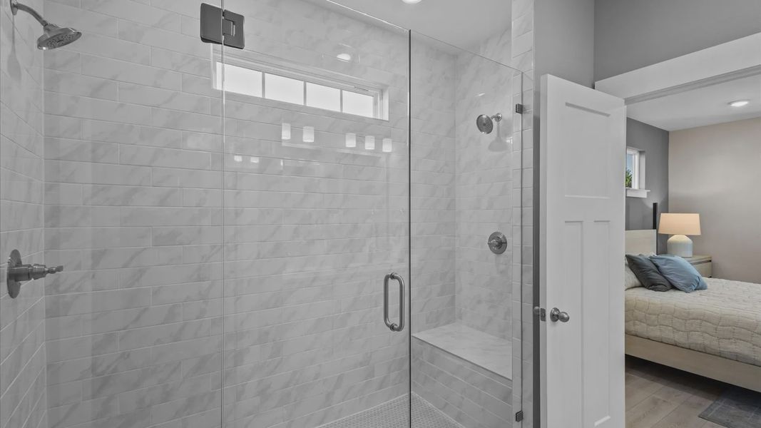 Elegant gray and white marble tile walk-in shower with glass door in Mint floorplan at Pleasant Falls in Moore, SC
