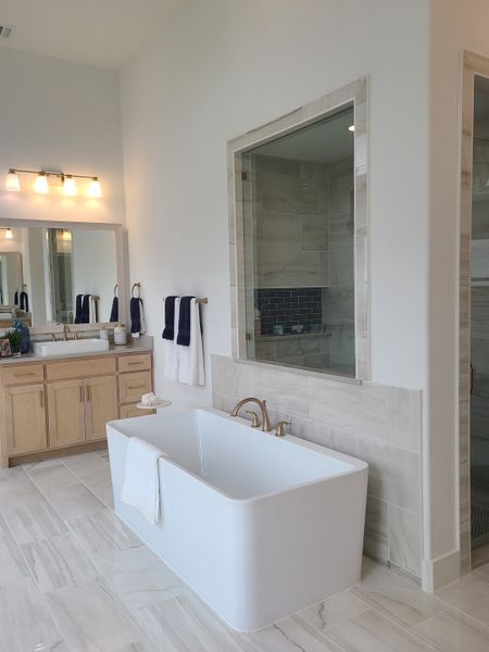 Elegant bathroom with a sleek freestanding tub, dual sinks, modern fixtures, and neutral tiling. Elegant bathroom with a sleek freestanding tub, dual sinks, modern fixtures, and neutral tiling.