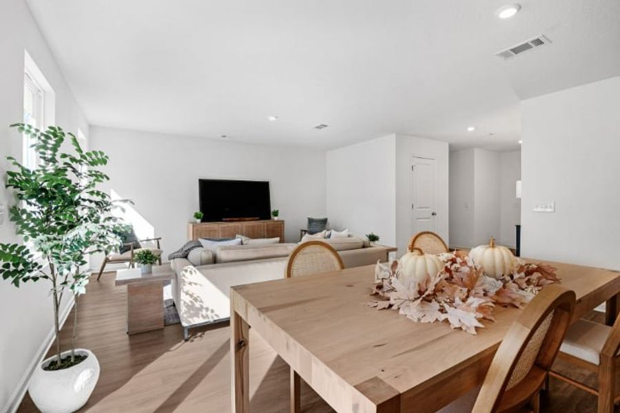 A living room with a table and chairs. A living room with a table and chairs.
