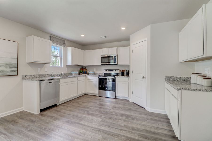 A kitchen with white cabinets.