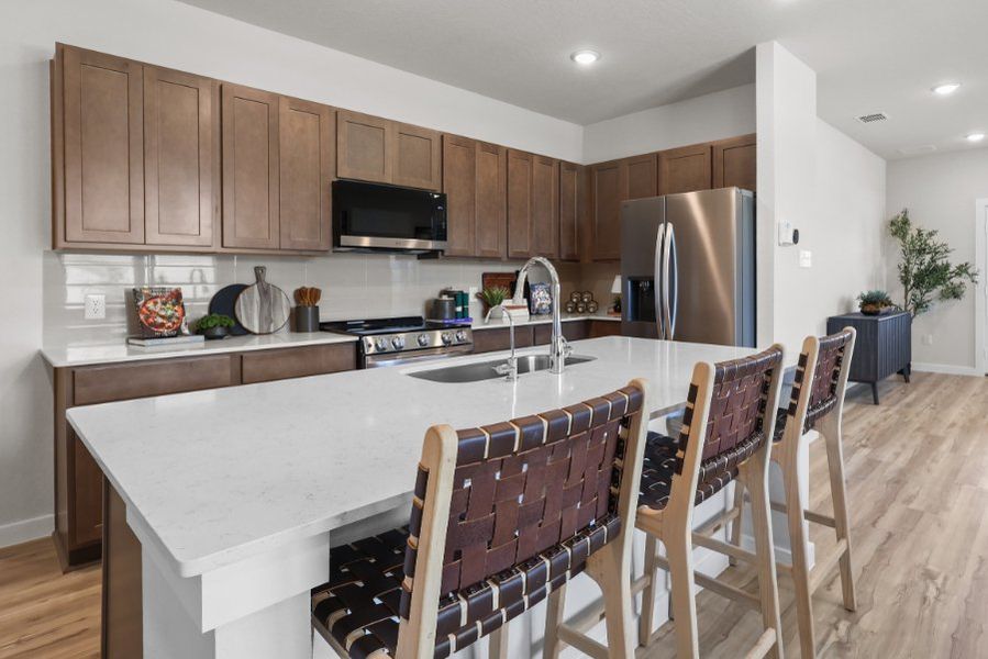 A kitchen with a bar and chairs.