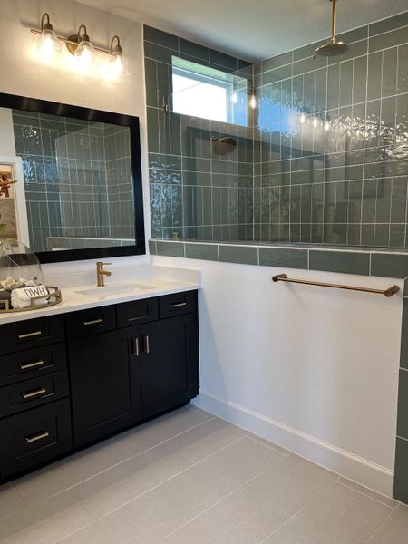 A contemporary bathroom featuring a sleek black vanity, modern lighting, and elegant tiled shower area. A contemporary bathroom featuring a sleek black vanity, modern lighting, and elegant tiled shower area.