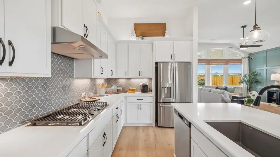 Sleek kitchen design with gas cooktop, vent hood, built-in oven, and modern finishes Sleek kitchen design with gas cooktop, vent hood, built-in oven, and modern finishes