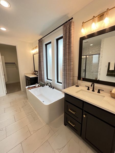 Elegant bathroom with a sleek freestanding tub, dual vanities, and modern fixtures creating a luxurious retreat.