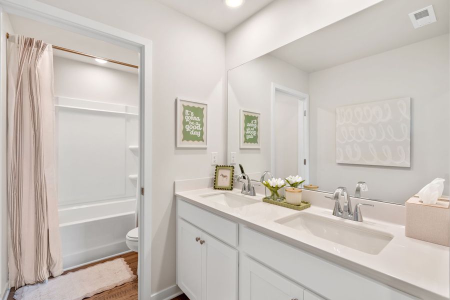 A bathroom with a tub sink and toilet.