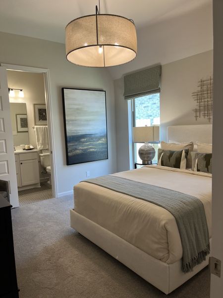 A cozy bedroom featuring a plush bed, soft lighting, elegant decor, and an en-suite bathroom for added convenience. A cozy bedroom featuring a plush bed, soft lighting, elegant decor, and an en-suite bathroom for added convenience.