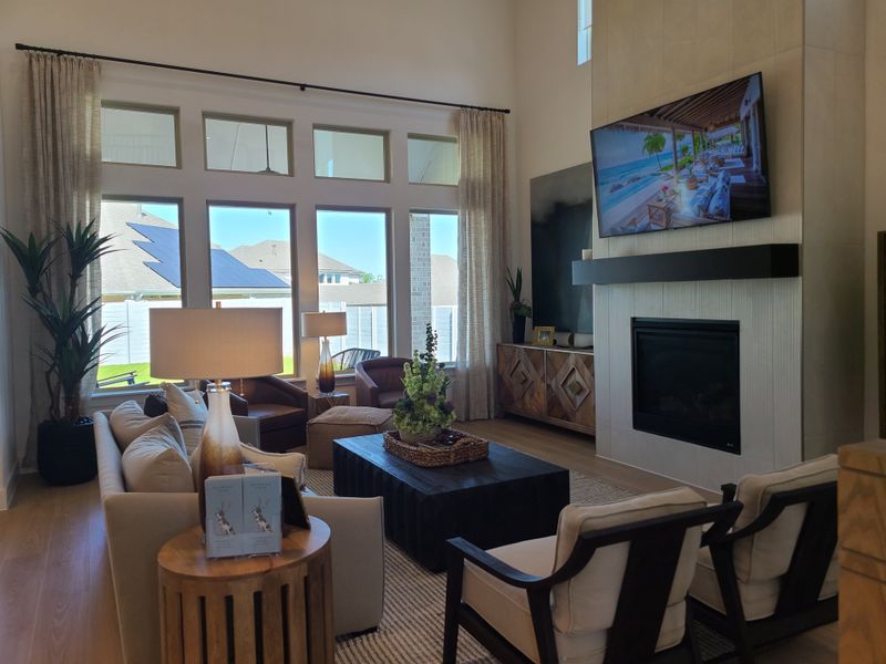 A sophisticated living room with floor-to-ceiling windows, modern fireplace, and stylish seating arrangement. A sophisticated living room with floor-to-ceiling windows, modern fireplace, and stylish seating arrangement.