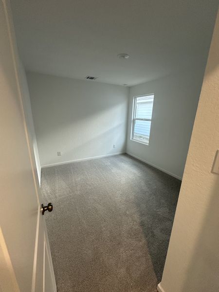 A cozy, carpeted room with bright natural light and a modern design.