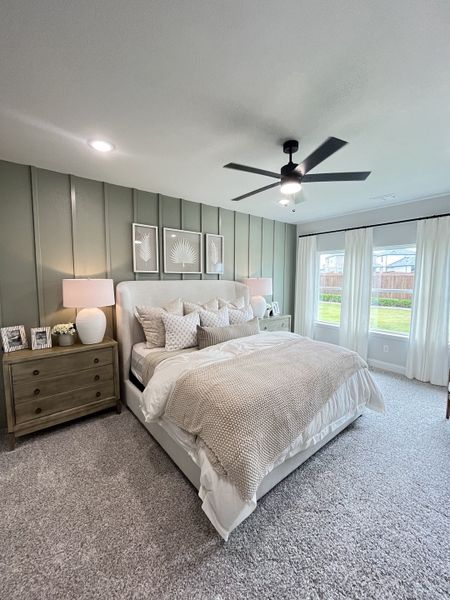 A cozy bedroom with elegant decor, featuring a plush bed, soft carpeting, and ample natural light.