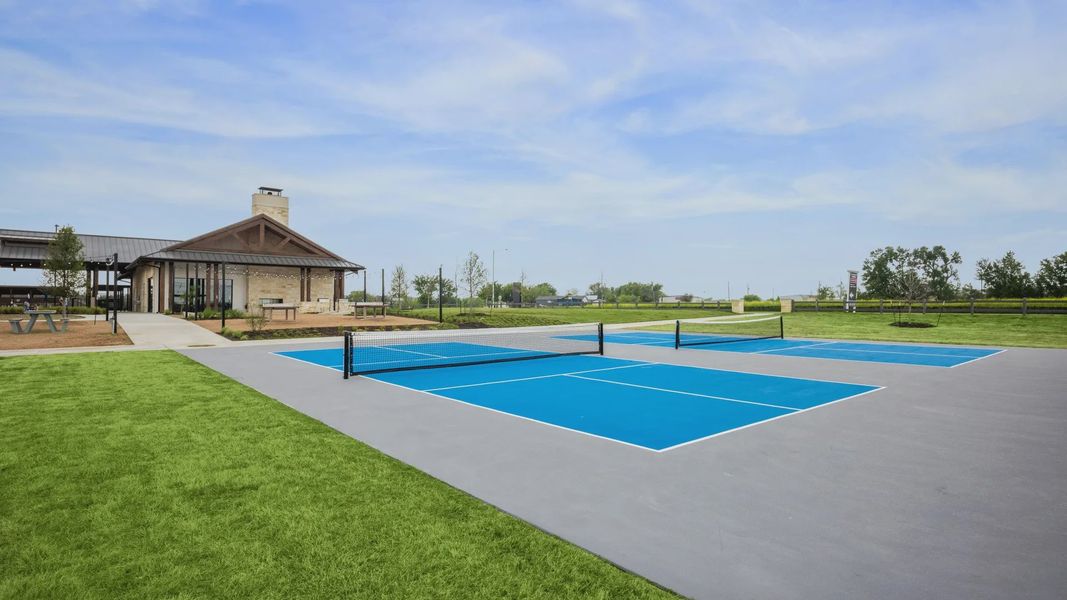Elegant clubhouse with a brick facade and tennis courts in Carillon, Texas. Luxurious recreational amenities. Elegant clubhouse with a brick facade and tennis courts in Carillon, Texas. Luxurious recreational amenities.