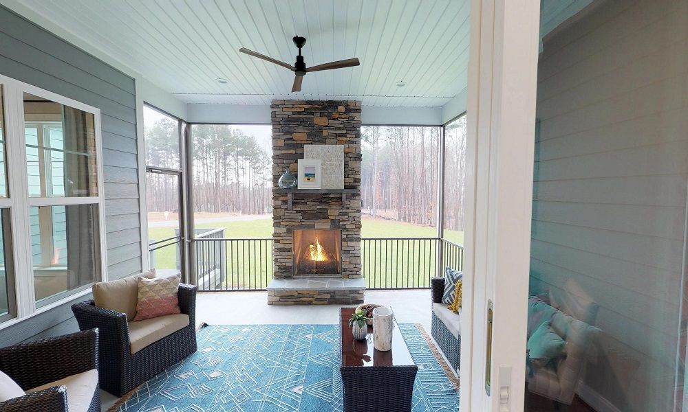 A Screened-in porch with stone fireplace.