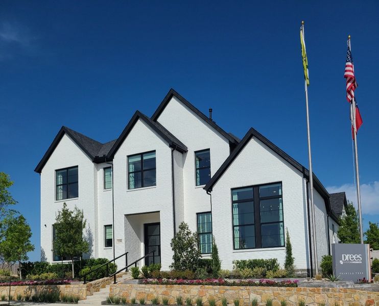 A beautiful white modern home with black trim in Painted Tree Woodlands by Drees Custom Homes (McKinney, TX).