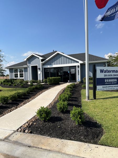 Charming blue model home with manicured landscaping in Watermark by D.R. Horton (Alvin, TX).