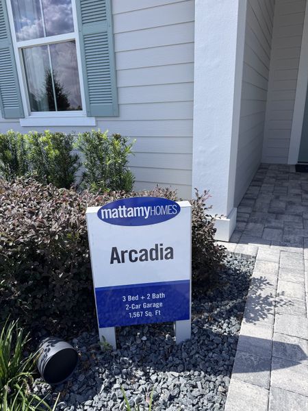 A stylish home exterior with blue shutters and a tidy garden in Sandridge Hills by Mattamy Homes (Green Cove Springs, FL).