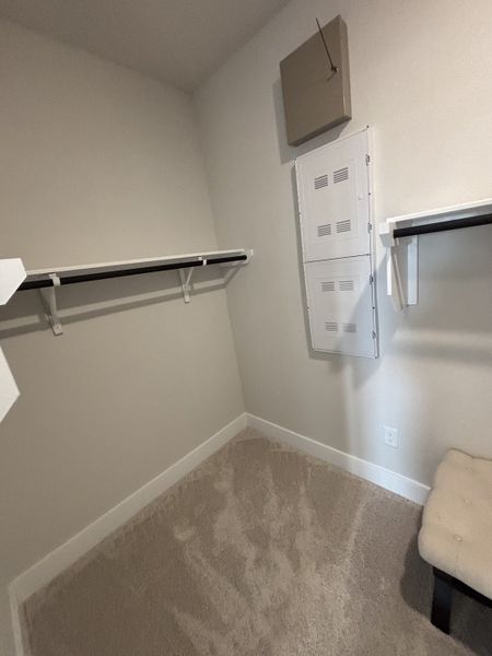 A generously sized walk-in closet with ample shelving and hanging space. A generously sized walk-in closet with ample shelving and hanging space.