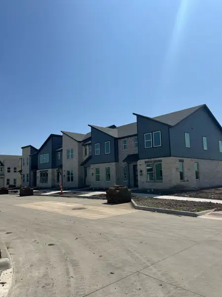 Contemporary townhomes with stone accents in Merritt Villas by Aspen Square Homes (Rowlett, TX), featuring modern design.
